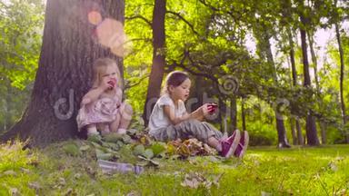 两个女孩<strong>坐在公园里</strong>吃石榴石